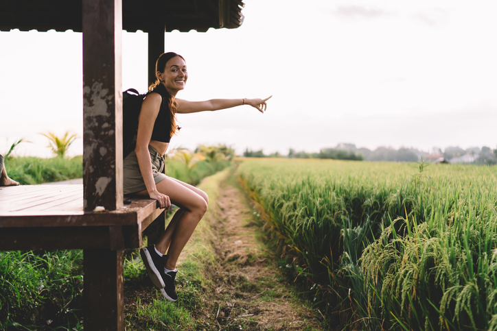 Happy woman showing destination sign