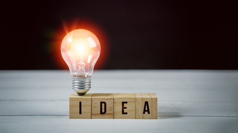 Concept idea, brainstorming, motivation, creativity, innovation, imagination, business solution and design, inspiration for creative invention. Idea word on wood block and light blub, no people.