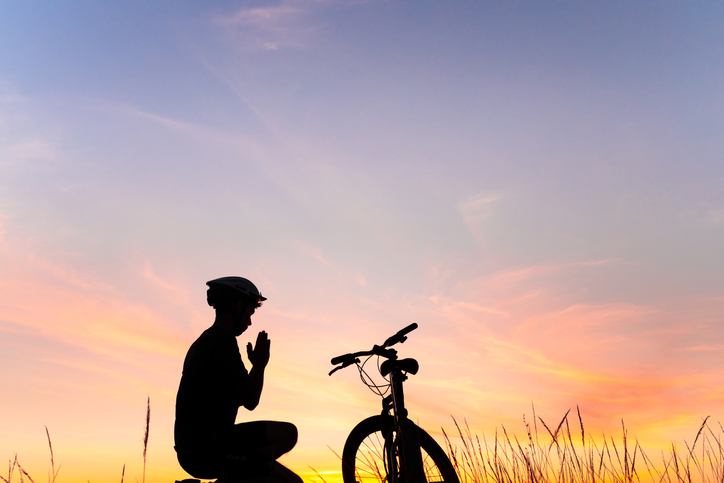 Cyclist praying to god