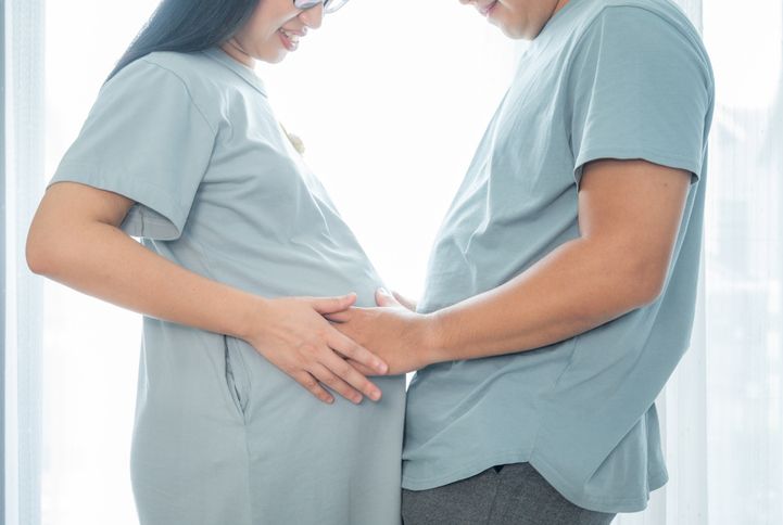 Cropped shot view of husband touching stomach to pregnant woman belly.