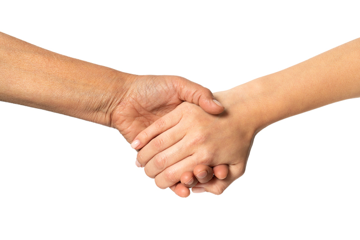 Elderly and young girls holding hands close-up. Help and frendly concept