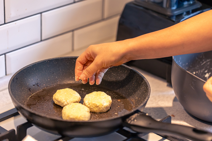 Cheesecakes are flying on a pan close-up, cheese pancakes.