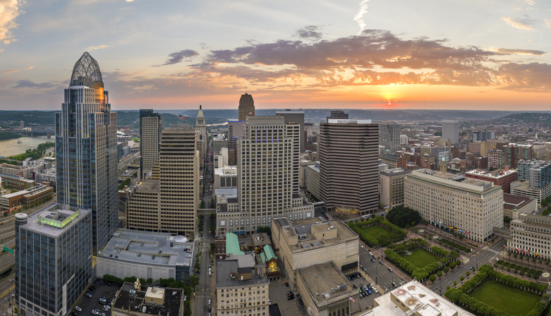 Cincinnati city in state of Ohio with brightly illuminated high skyscraper buildings in downtown district. American megapolis with business financial district at sunset