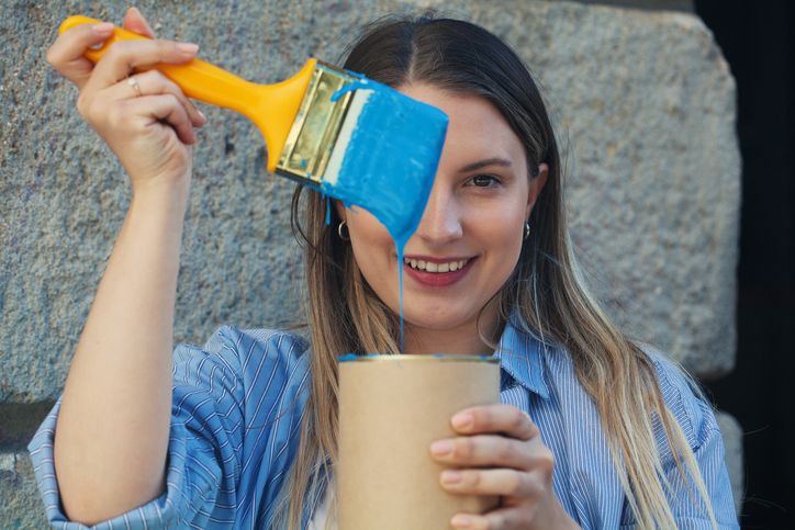 Young woman painting a wall