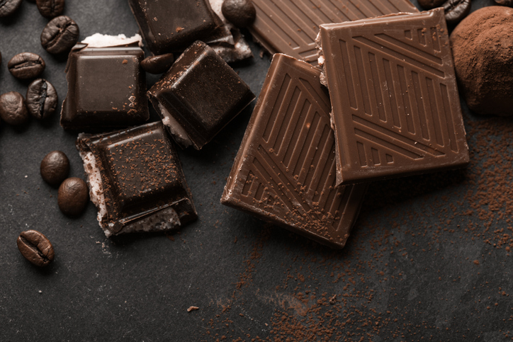 Delicious chocolates and spices on a black background.