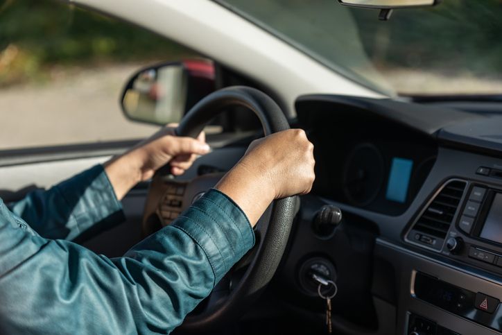 Driver hands on steering wheel. Woman driving car in a city. Female hands holding car steering wheel