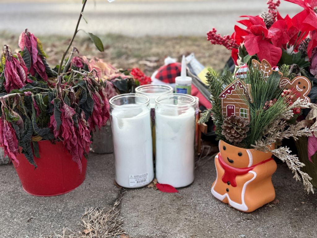 Juguetes, flores y velas en memoria de familia hondureña