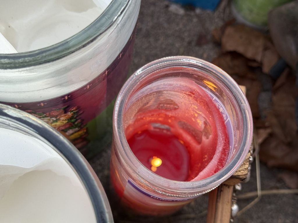 Juguetes, flores y velas en memoria de familia hondureña