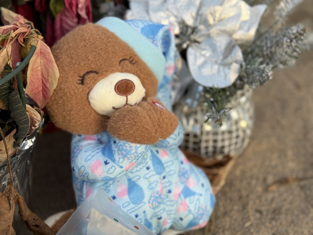 Juguetes, flores y velas en memoria de familia hondureña