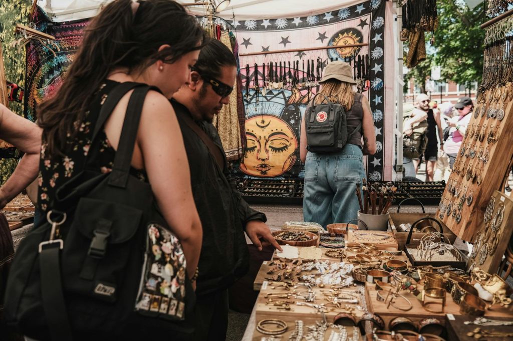 people looking at jewelry stalls at a market