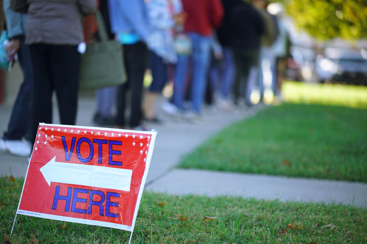 Low angle view of people lined up to vote - stock photo