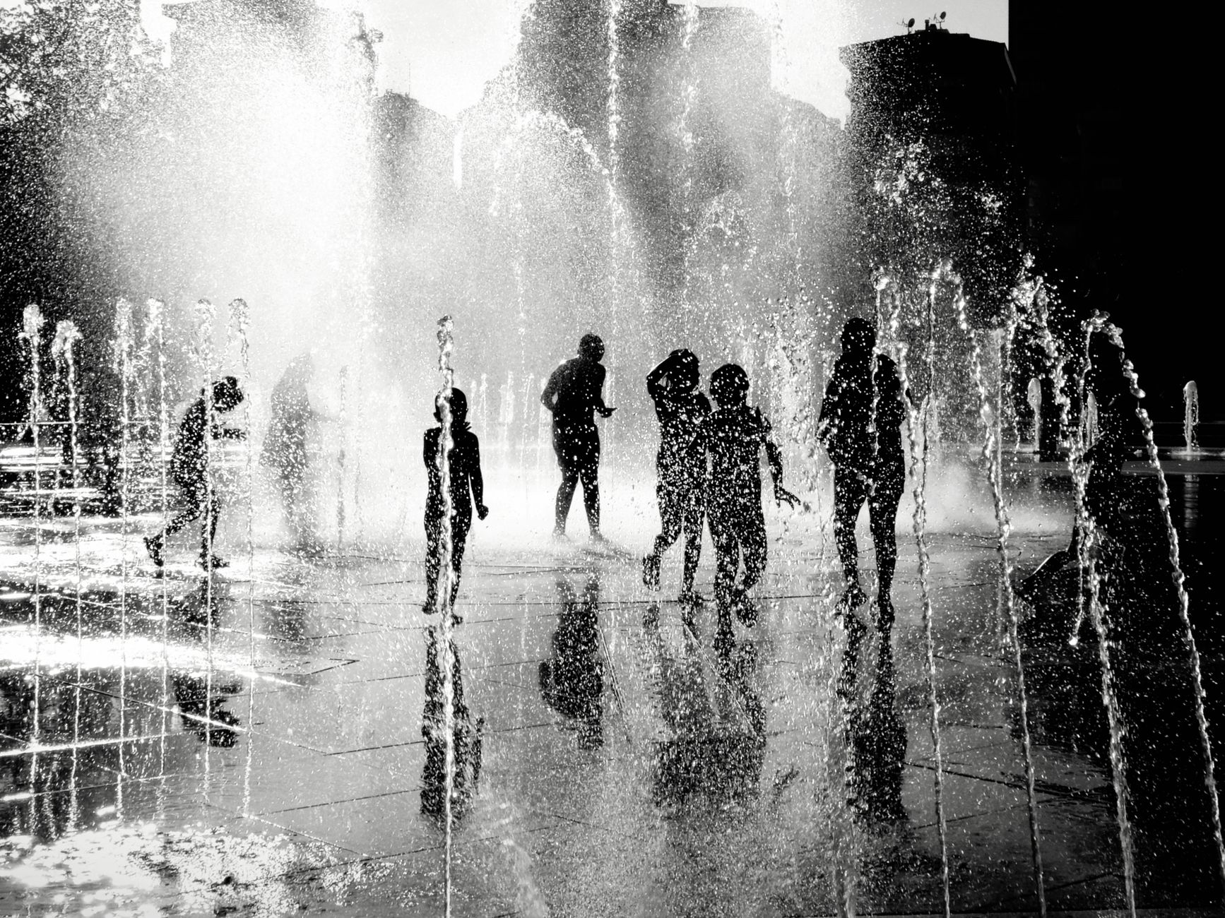 silhouettes playing in water fountain istanbul