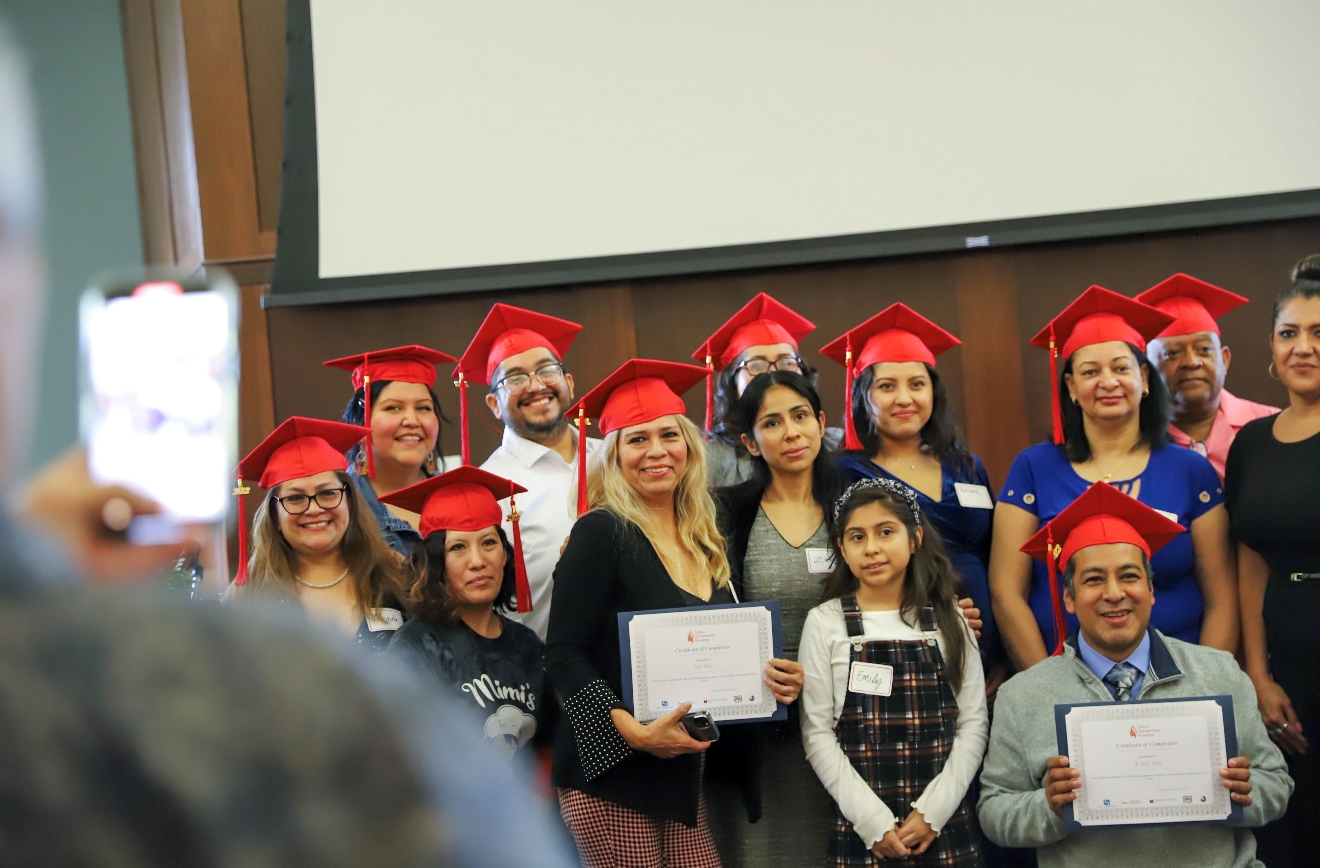 A group of people in graduation caps and gowns holding diplomas, celebrating their academic achievements.